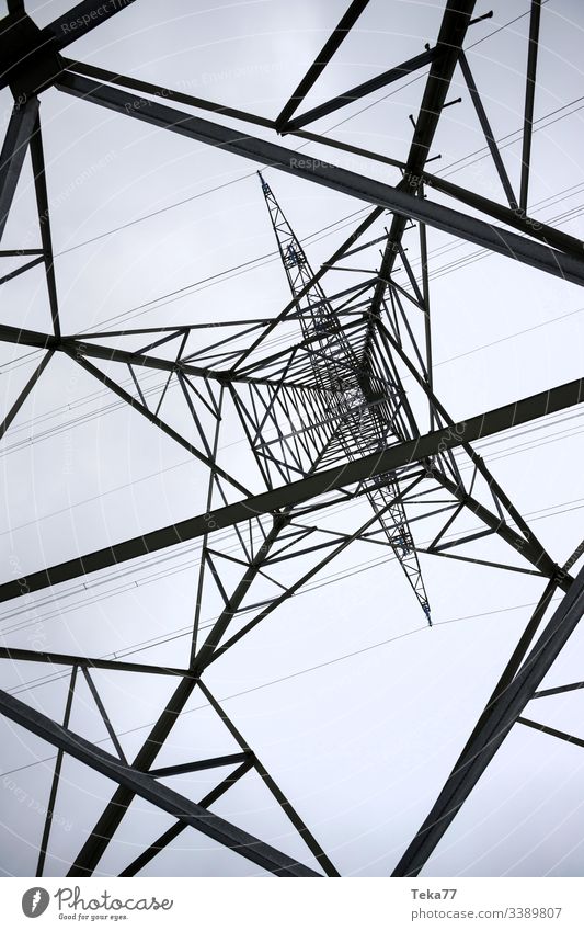 an electricity pylon from below perpendicular energy cable Electricity pylon high voltage energy tranportation ampstorm sun lightning power plant power cable