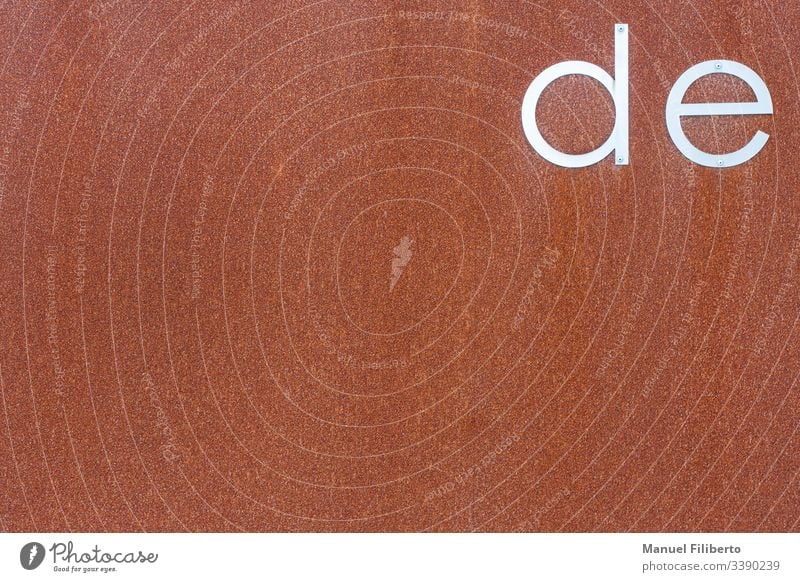 rusty iron plate with the letters "de" in stainless steel metal typographic words textured language dictionary talk speech expression communication presentation
