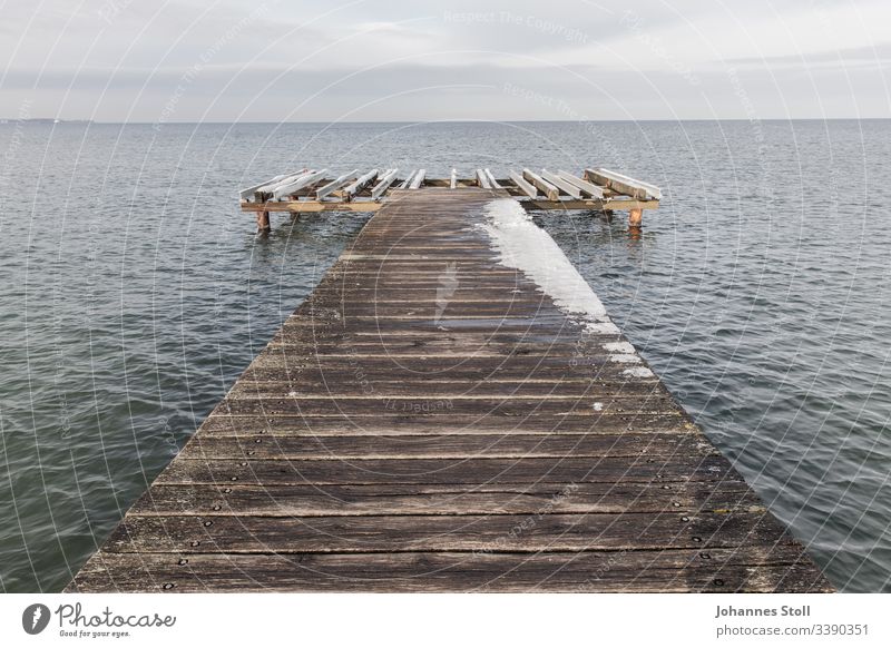 Wooden jetty with snow on the Baltic Sea shore Footbridge investor wharf wooden walkway Gangway Harbour bank Beach Ocean Lake lake view ostssee Keel boat ship