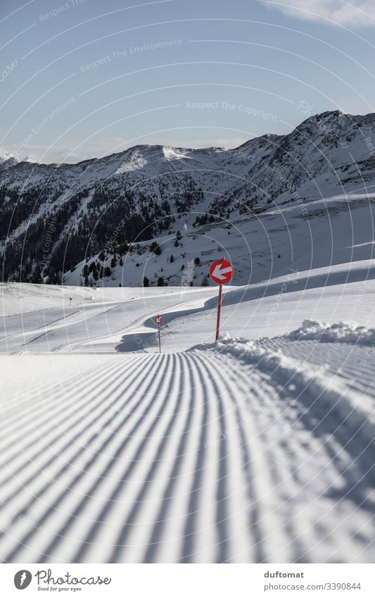 Piste marking in fresh snow on freshly prepared piste panorama mountains Snow plate lift Skiing Valley skis powder Beginner Cold Ski piste Sunrise Tracks