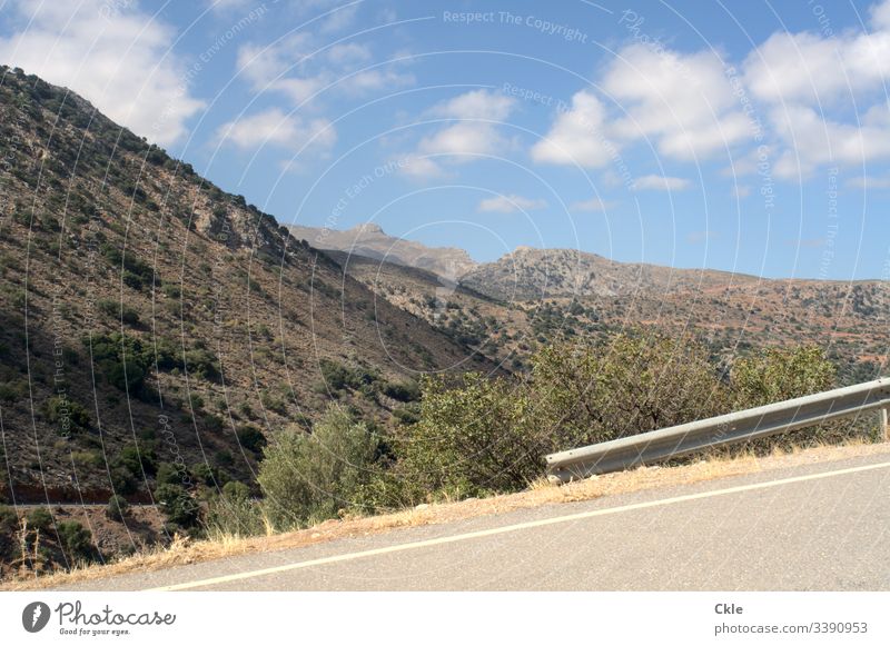 Lonely road in mountains of the island of Crete Peak Street abyss Crash barrier Summer Drought Loneliness Blue sky Clouds Greece Wide angle panorama