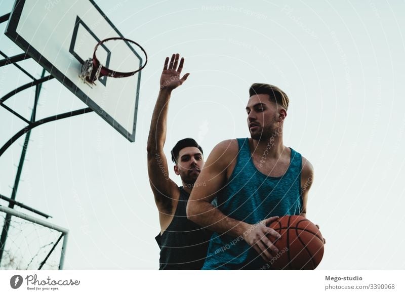 Young basketball players playing one-on-one. game youth sport court male young team together active action playground exercise men friendship jump happy athlete