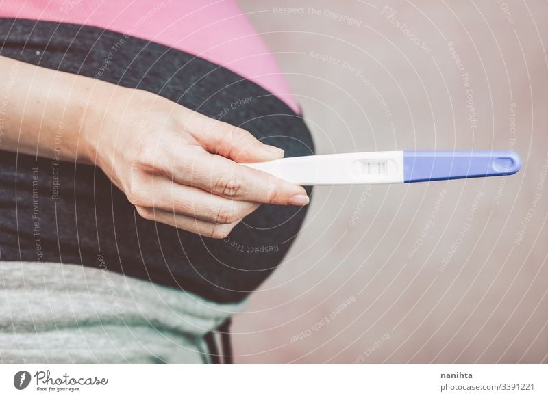 Woman holding a positive pregnancy test pregnant mom mother woman family happiness happy pink close up belly month week third proof love lovely mid section body