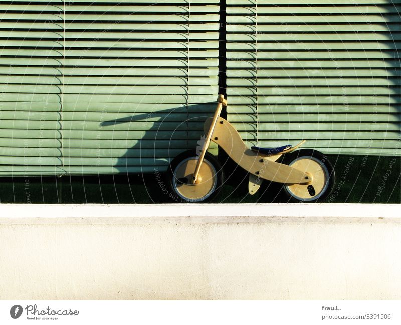 The small wheel is waiting in front of dusty window blinds, longing to be bought at last impeller Exterior shot Playing Shop window Bicycle Wait Roller blinds