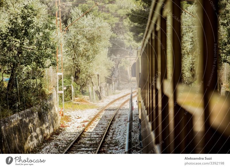 Retro wooden train traveling along railroad in mountains. Beautiful sunny summer landscape. Majorca, Spain. adventure beautiful commuter countryside destination