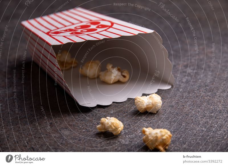 Some popcorn in a bag on the floor Popcorn Paper bag Cinema Remainder Interior shot Food Snack Delicious Maize Close-up Fast food Eating Salty Sweet Candy