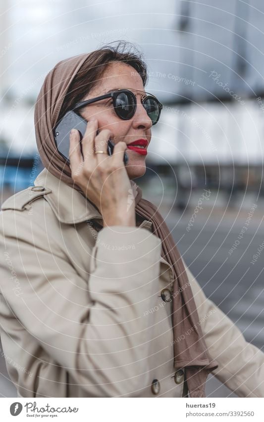 Arab woman with hijab talking on the phone female attractive suitcase muslim muslim woman mobile phone arab baggage travel: islamic traveler arabian arabic trip