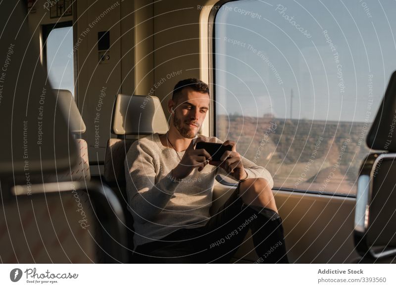 Young male passenger using smartphone in subway man wireless earphones text messaging cellphone lean on listen music train metro connection communicate device