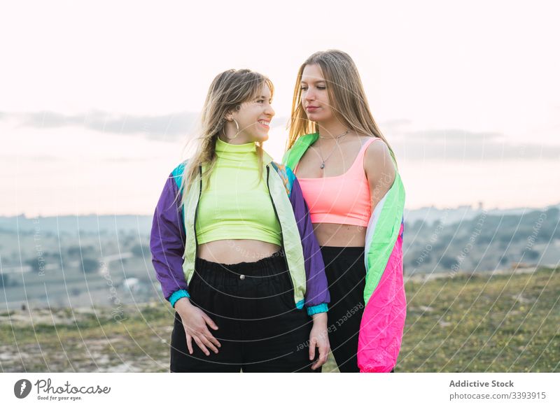 Cool modern females chatting on rural field women hipster teenager girlfriend colorful cool group wear attire rebel smile laugh enjoy talk conversation