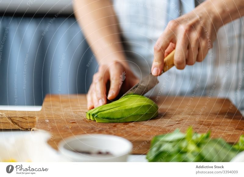 Woman cutting avocado on cutting board food cooking knife recipe woman vegetable ingredient add healthy green kitchen meal female housewife dinner lunch home