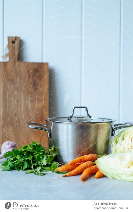 Fresh vegetables and herbs near saucepan cook kitchen dish lunch parsley carrot cabbage food preparation home meal ingredient culinary cuisine organic natural