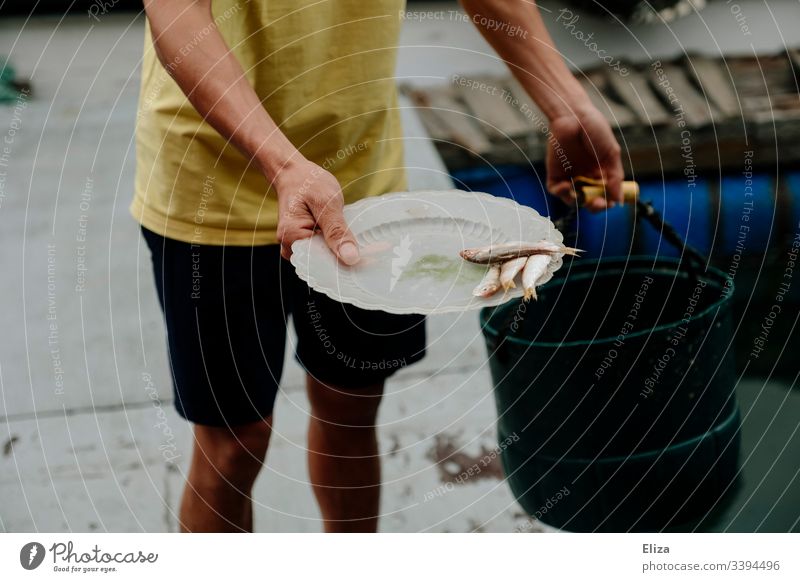 A fisherman holds a plate with fish in his hand Fisherman fishing Fish breeding Feed Plate Man stop feed Water Fishery Documentary Vietnam Fishing (Angle) Catch