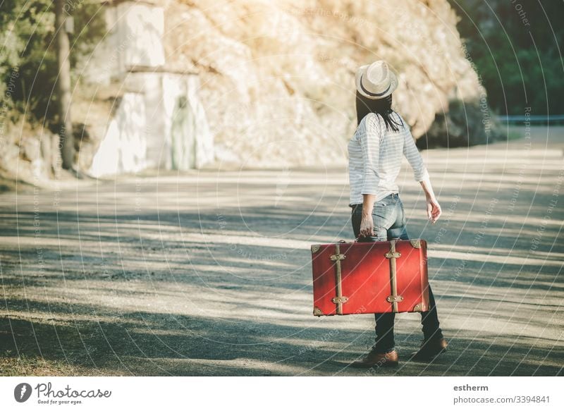 Young woman with suitcase on the road freedom fun girl happiness happy hat highway hitchhiker hope independence holidays adventure lifestyle motorway nature