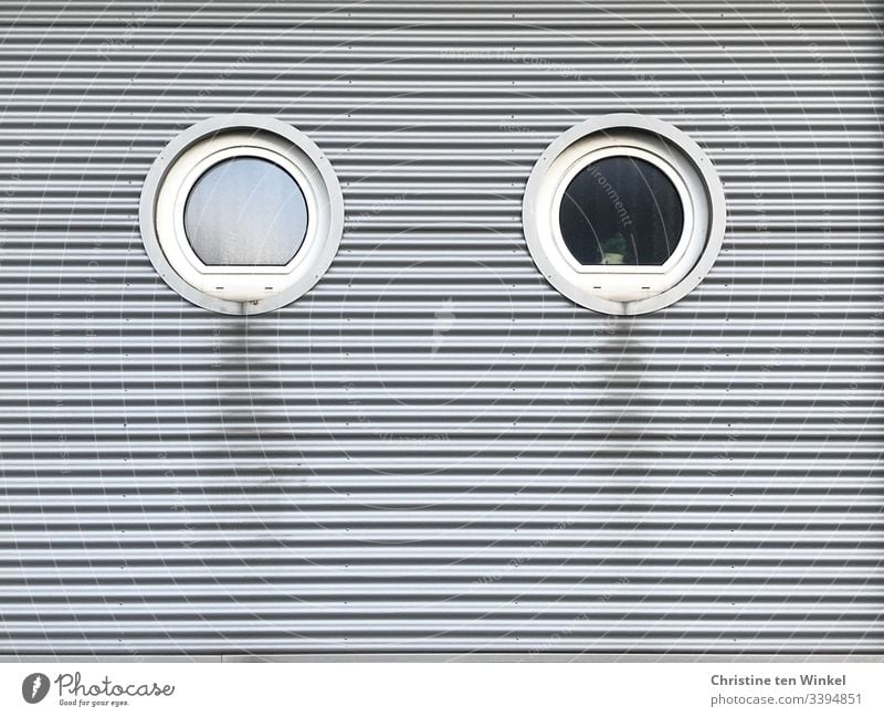 Two round windows in a clad house facade Window Round White Facade Building facade frowzy Silver Cladding silver Gray Gloomy Stripe lines Day Architecture built