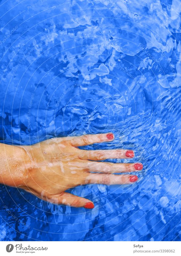 Classic blue color of 2020. Female hand in water classic woman spa harmony red manicure wellness nails nail polish vacation background female trend classical