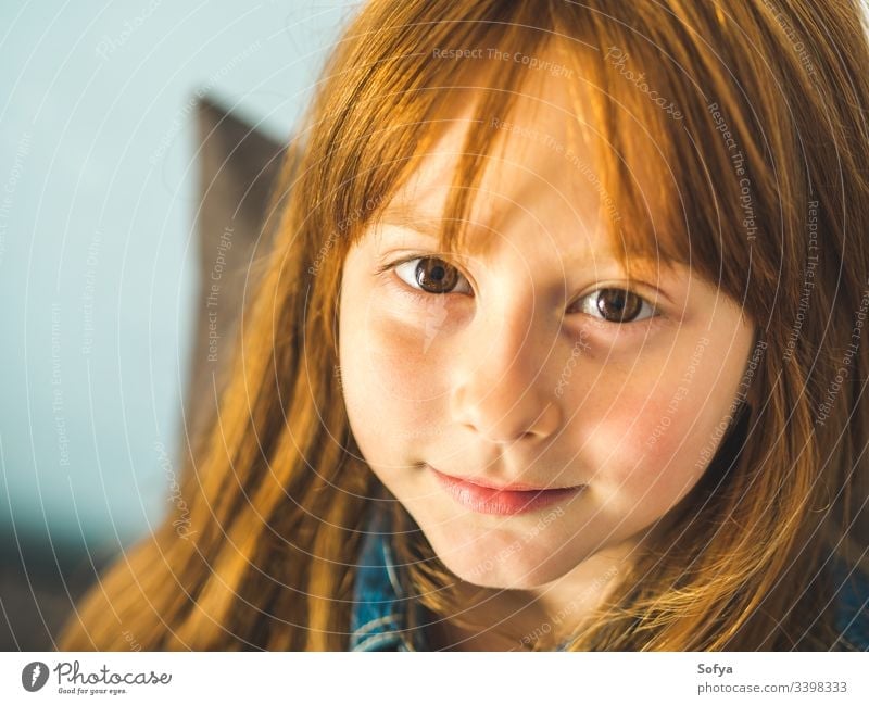 Cute redhead little girl looking at us and smiling cute child vivid eyes young cheerful smile kid hair ginger happy joy enjoy selfconfident face skin freckles