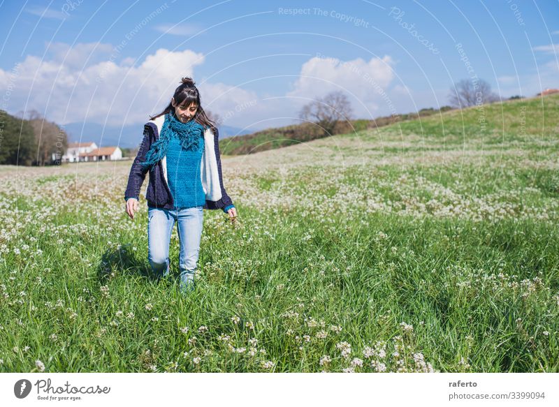 Front view of hispanic brunette woman in casual wear walking on field flower green back freedom spring 1 nature female alone summer beauty old adult countryside