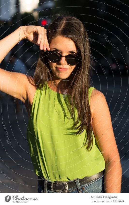 Woman portrait outdoors with green shirt in summer woman pretty beauty daylight sunset shorts body professional photography model sunglasses smile face mouth