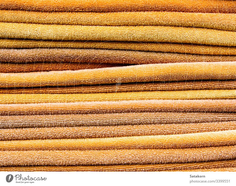 Pile of yellow towels pile stack clean orange color bath laundry background texture soft fabric cotton wipe objects bathroom shower