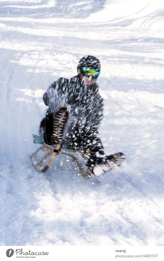 Unrecognizable person has a lot of fun sledging in the wildly splashing snow Sledding fun factor Snow Human being Winter Exterior shot Cold Leisure and hobbies