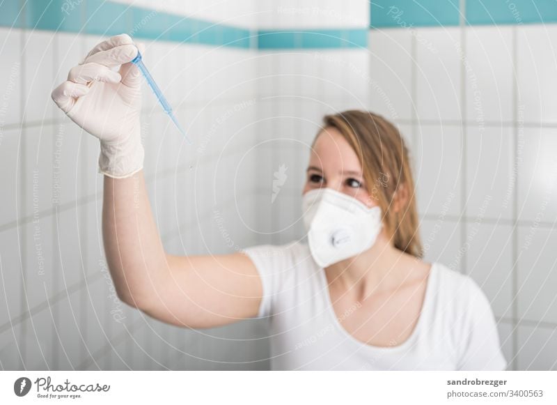 Nurse with mouth guard examines laboratory sample coronavirus covid-19 Virus Illness pandemic Epidemic Mask guard sb./sth. disposable gloves hand protection