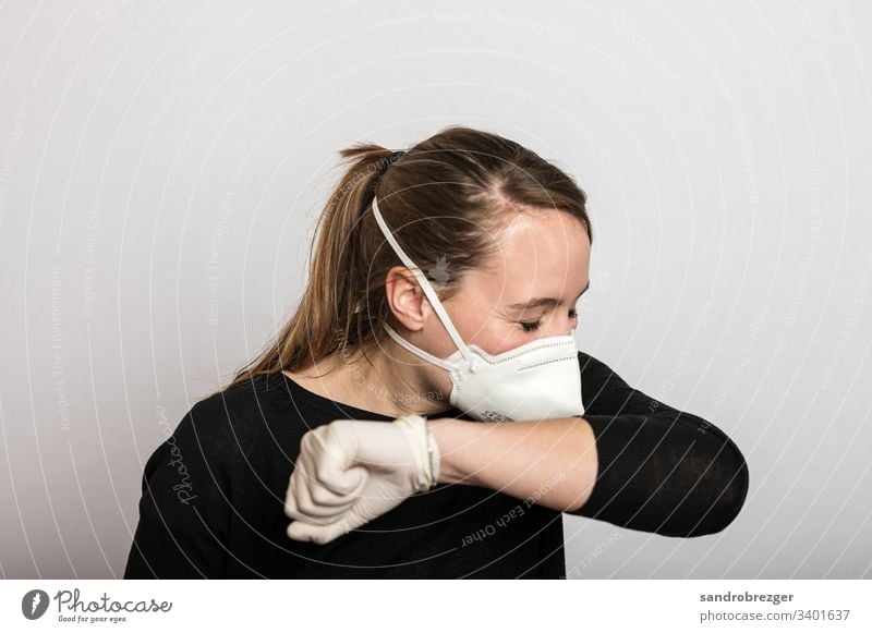 Woman with mouthguard and disposable gloves sneezes into the crook of her arm coronavirus covid-19 Virus Illness pandemic Epidemic Mask guard sb./sth.