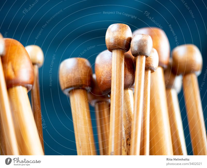 wooden knitting needles Blockheads Group symbol Knit Detail Close-up shallow depth of field warm colors Brown tones dark blue Copy Space top Leisure and hobbies