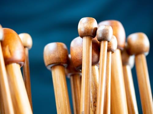 wooden knitting needles Blockheads Group symbol Knit Detail Close-up shallow depth of field warm colors Brown tones dark blue Copy Space top Leisure and hobbies