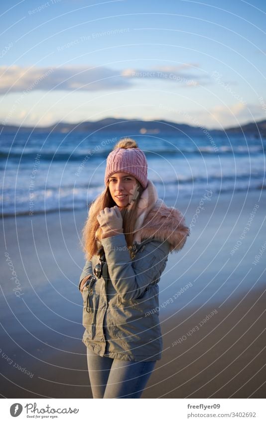 Young woman going for a walk on the beach in winter young beanie walking vigo galicia spain sea atlantic happy relaxed female caucasian romantic joy sand middle