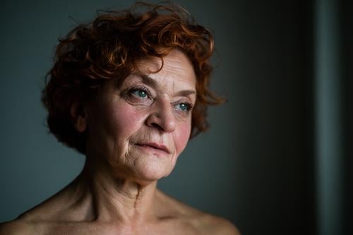 Mature woman by the window thinking about life adult age aged aging alone beautiful beauty care caucasian close-up closeup contemplating depression elder