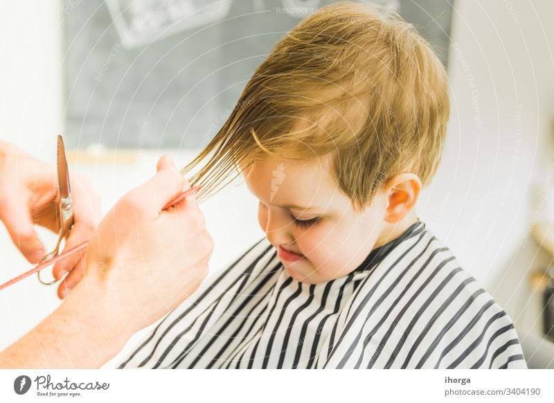 the little boy in a hairdressing salon adorable baby barber barbershop beauty blond care caucasian chair child childhood children comb cut cute face fashion