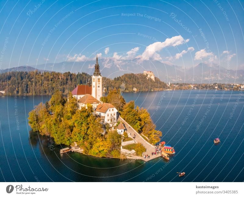 Aerial view of Bled island on lake Bled, and Bled castle and mountains in background, Slovenia. slovenia bled scenic landmark church julian water scenery europe