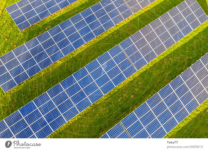 a modern solar cell park from above solar cells sun sun rays sun beams blue white hot yellow grass meadow green clouds reflections lithium modern solar cells