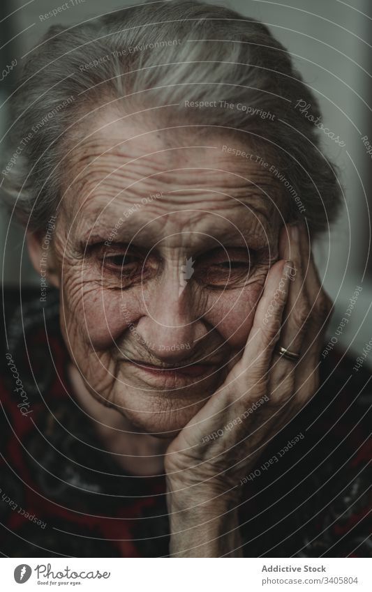 Pensive senior woman touching face elderly wrinkle touch face remember memory pensive tranquil gray hair kind appearance female individuality personality