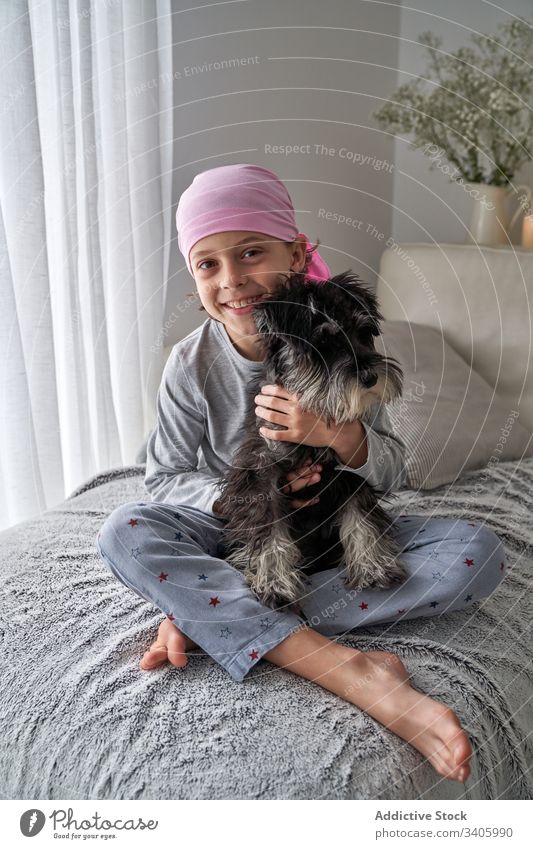 Cute little child playing with dog on bed sick boy caress pet home breed therapy animal male help faith love support recovery patient disease oncology