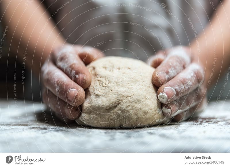 Crop baker kneading dough on table flour bakery cook kitchen ingredient food prepare bread work job chef tradition pastry raw cuisine recipe soft occupation