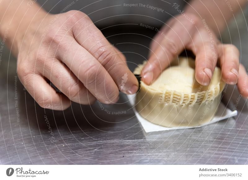 Crop baker making small pie cook table bakery pinch crust dough work kitchen prepare food cuisine fresh ingredient pastry hand body part job tasty chef raw