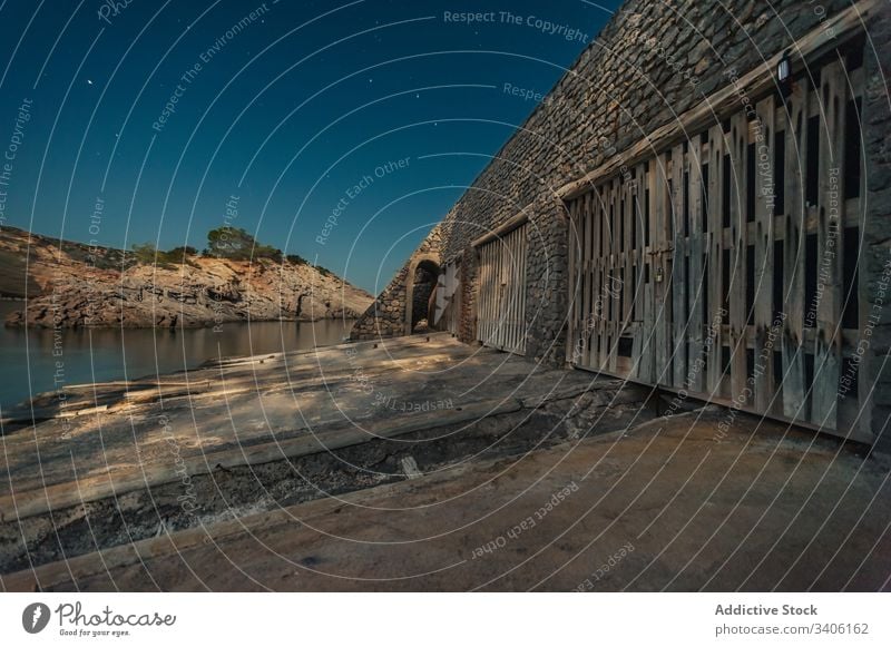 Old stone building on coast at night old shore sea sky star ibiza Cala Es Canaret spain architecture water destination construction scenic exterior evening aged