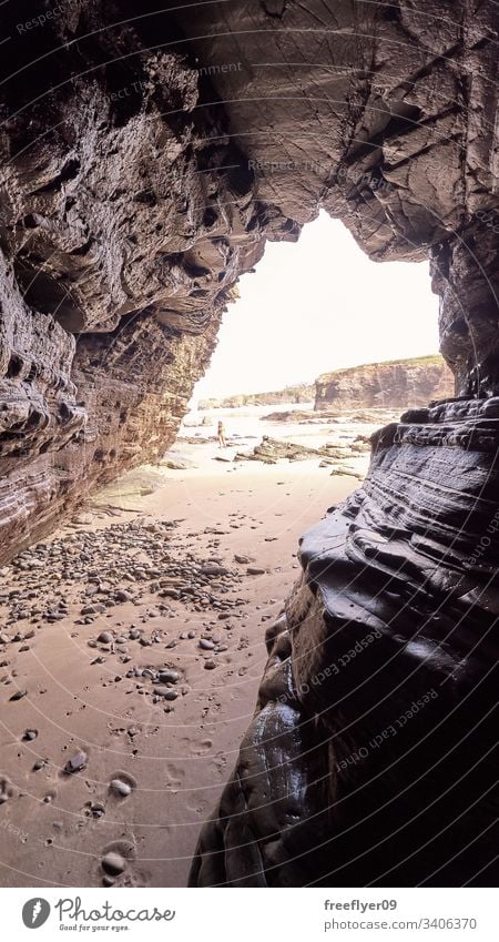 Landscape of a beach with rocky cliffs in Galicia from the interior of a cave tourism hiking galicia spain ribadeo castros illas atlantic bay touristic