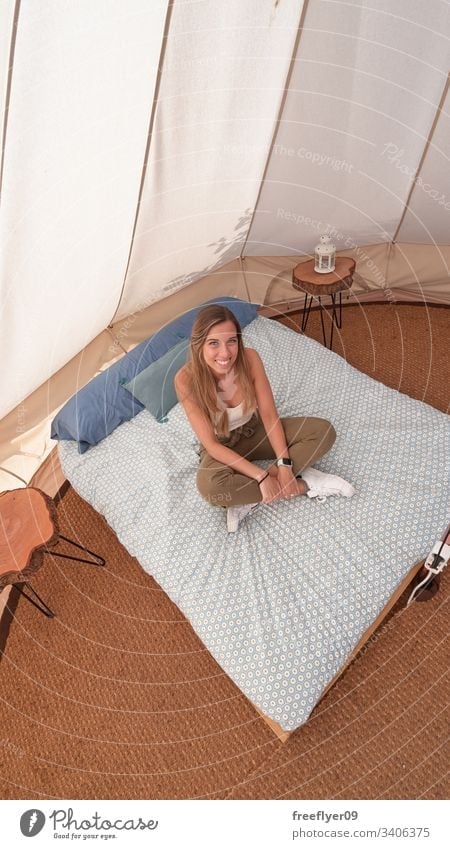 Young woman on the interior of a camping tent tourism hiking glamping big site vacation outdoor comfort sheets beautiful comfortable summer inside resort