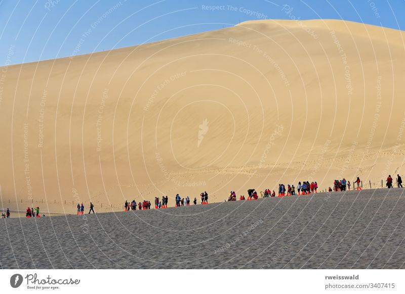 Sled-riders on the dunes around Crescent lake-Yueyaquan oasis. Dunhuang-Gansu-China-0661 several people many people people in row queue Chinese tourist visitor