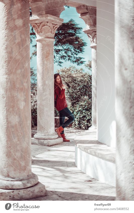 Young woman supported by a column smiling at camera young sunglasses boots brown yellow standing posing blonde jeans backpack instagram look mood tourist hiker