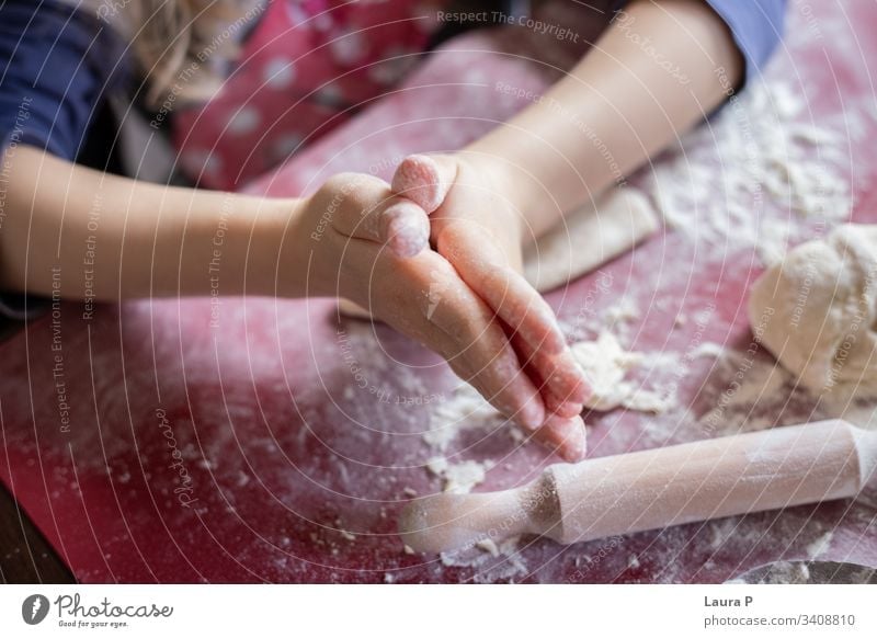 Close up of child hands next to a rolling pin, playing with dough desert Preparation Raw Kitchen Close-up adorable cute sweet close up little baking cooking