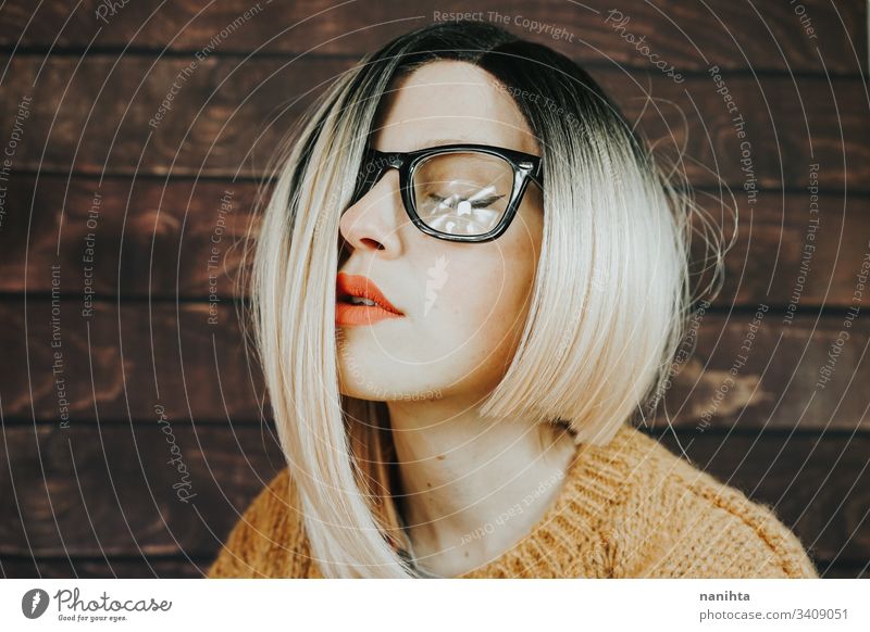 Close portrait of a beautiful nerdy woman glasses eyewear fashion trendy model blonde rimmed glasses ombre hairstyle cool attractive pretty face accessories