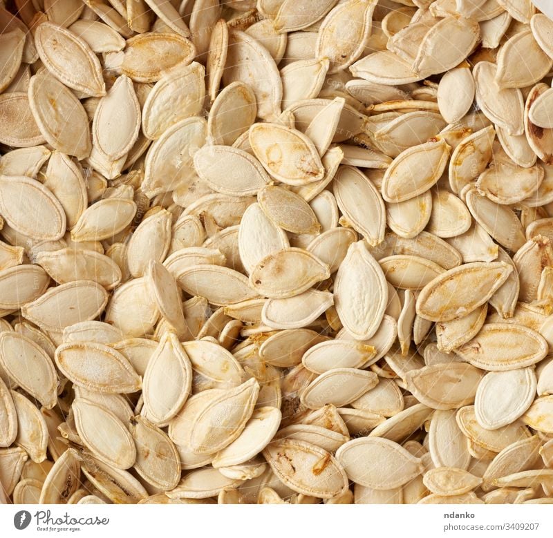 dry raw pumpkin seeds, full frame food healthy vegetarian background organic vegetable fresh diet white meal nutrition natural yellow ingredient delicious snack