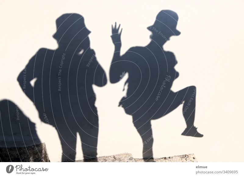 two shadow people Shadow Shadow person fun Funny Distorted Hat summer fun Happiness Happy Smiling Lifestyle silhouette at the same time free time Together