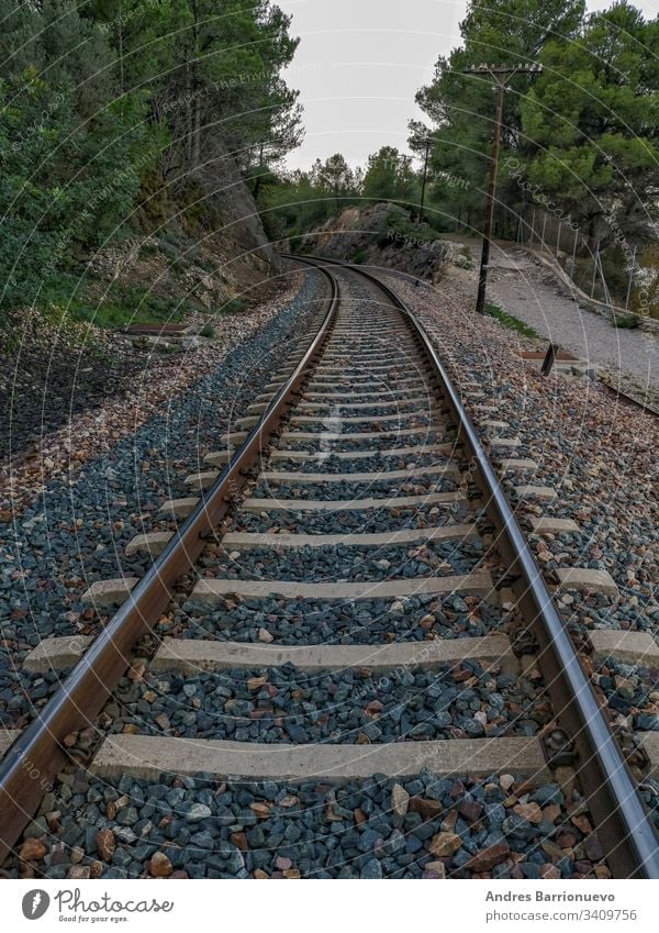 Train track through the mountain rock gorge business outdoor curving industry wood park cargo travel rail iron sign country direction gravel cloudy
