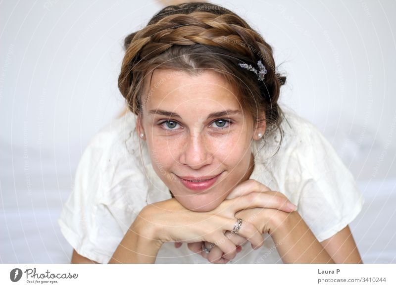 Young smiling woman with braided hair, dressed in white young face natural look close up portrait green eyes peaceful nice beautiful beauty fresh silent