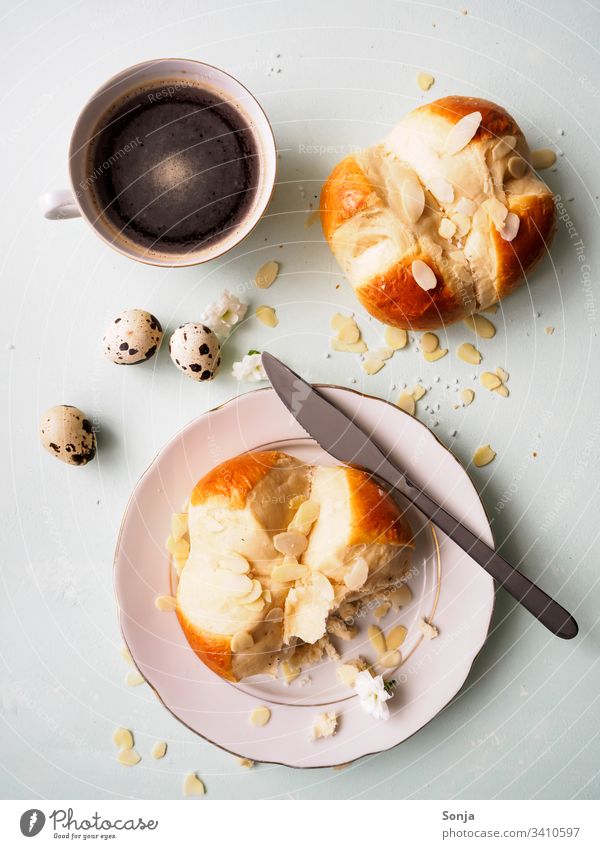 Ostergebäck mit Mandeln und Zucker und eine Tasse Kaffee auf einem hellgrünen Küchentisch brioche Frühstück ostern osterbrunch morgen dessert Home-made