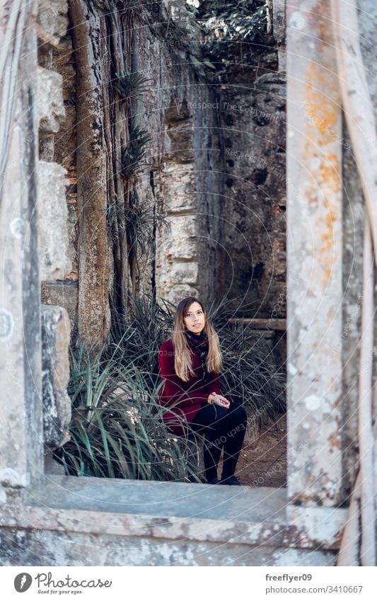 Woman sitting on the ruins of an antique church tourist abandoned building convent moss famous historical history national place rock monastery park art sun